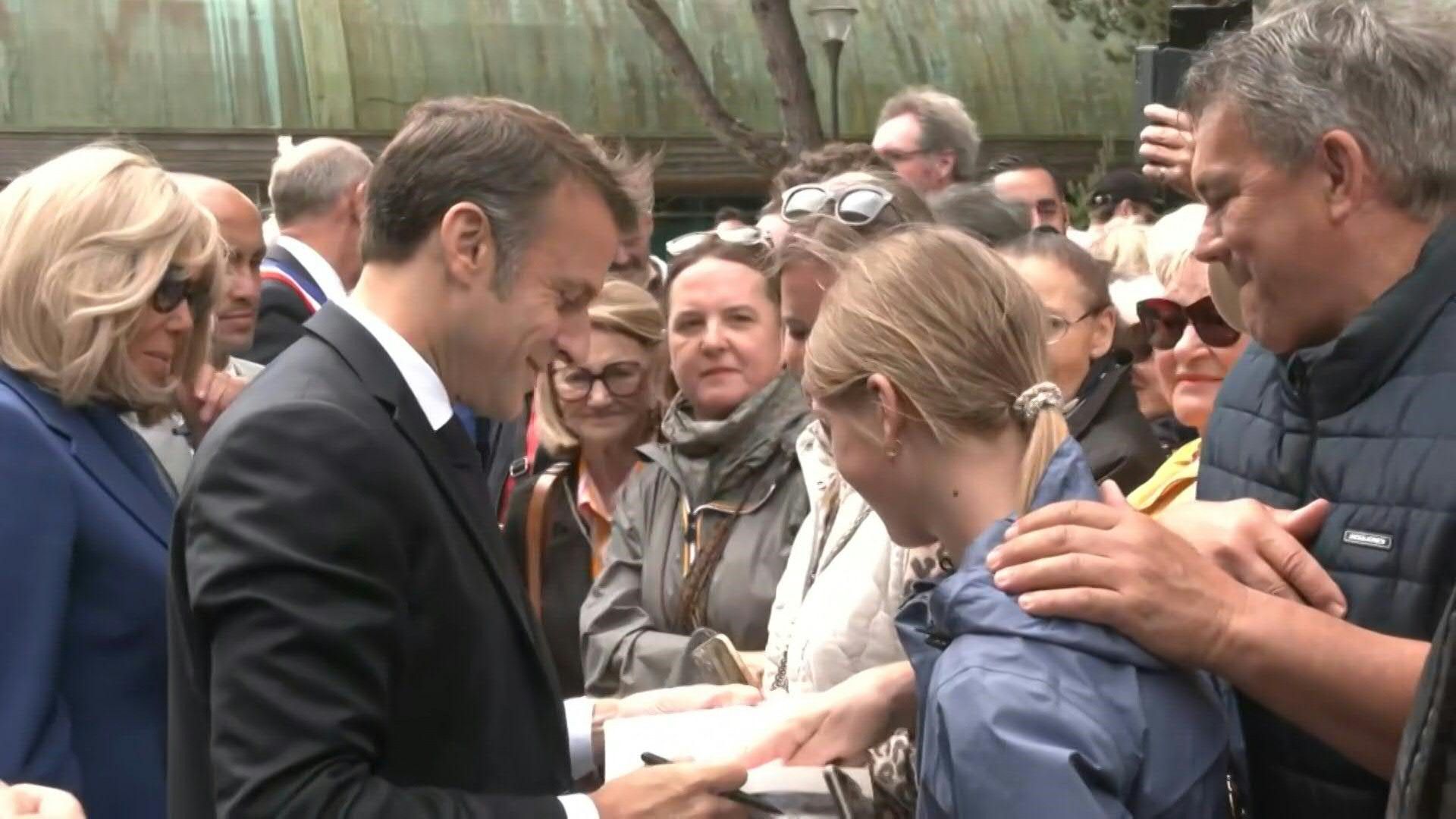 Emmanuel Macron greets residents after casting his vote