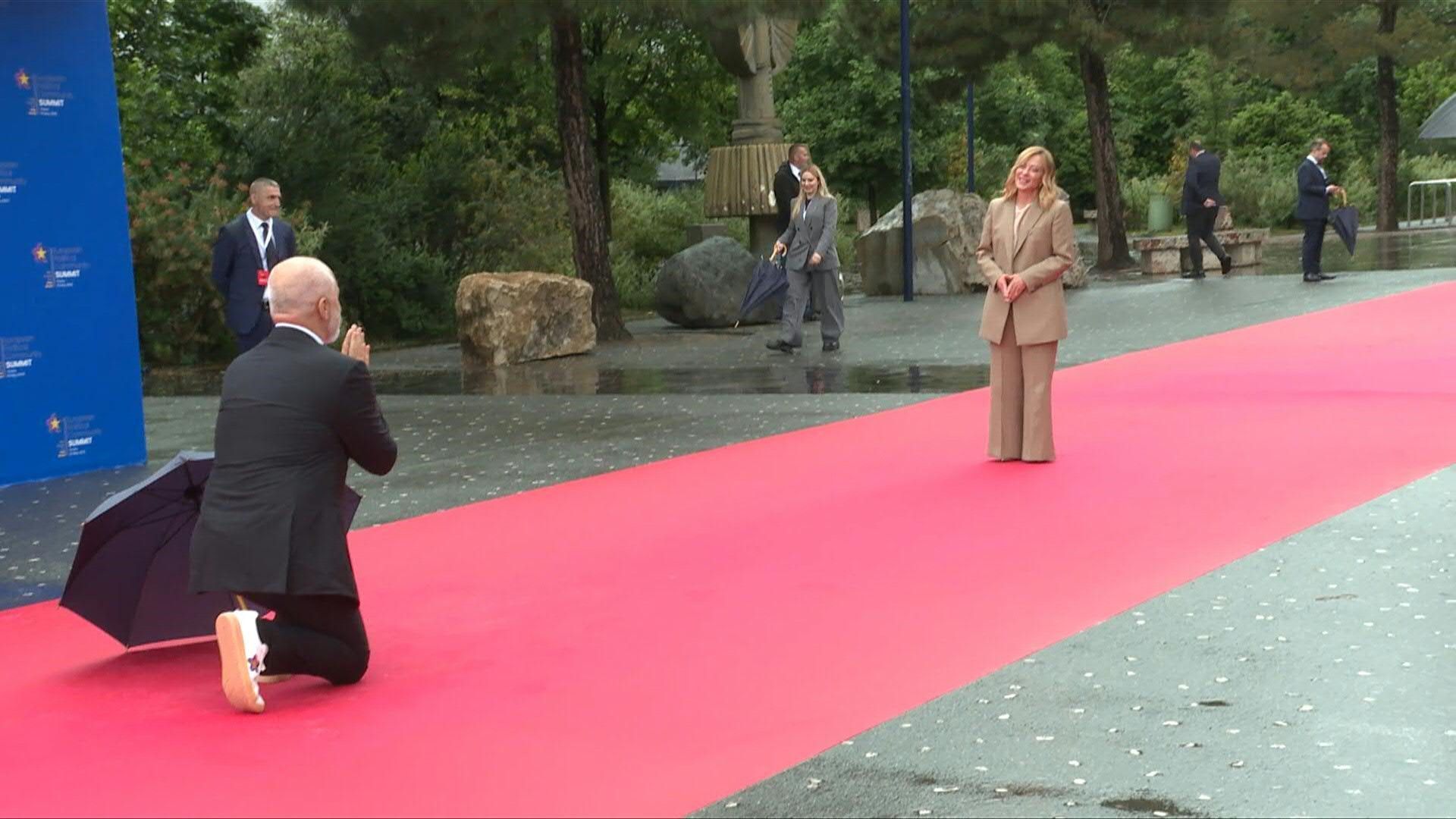 Albanian PM Rama kneels playfully to greet Italy's Giorgia Meloni