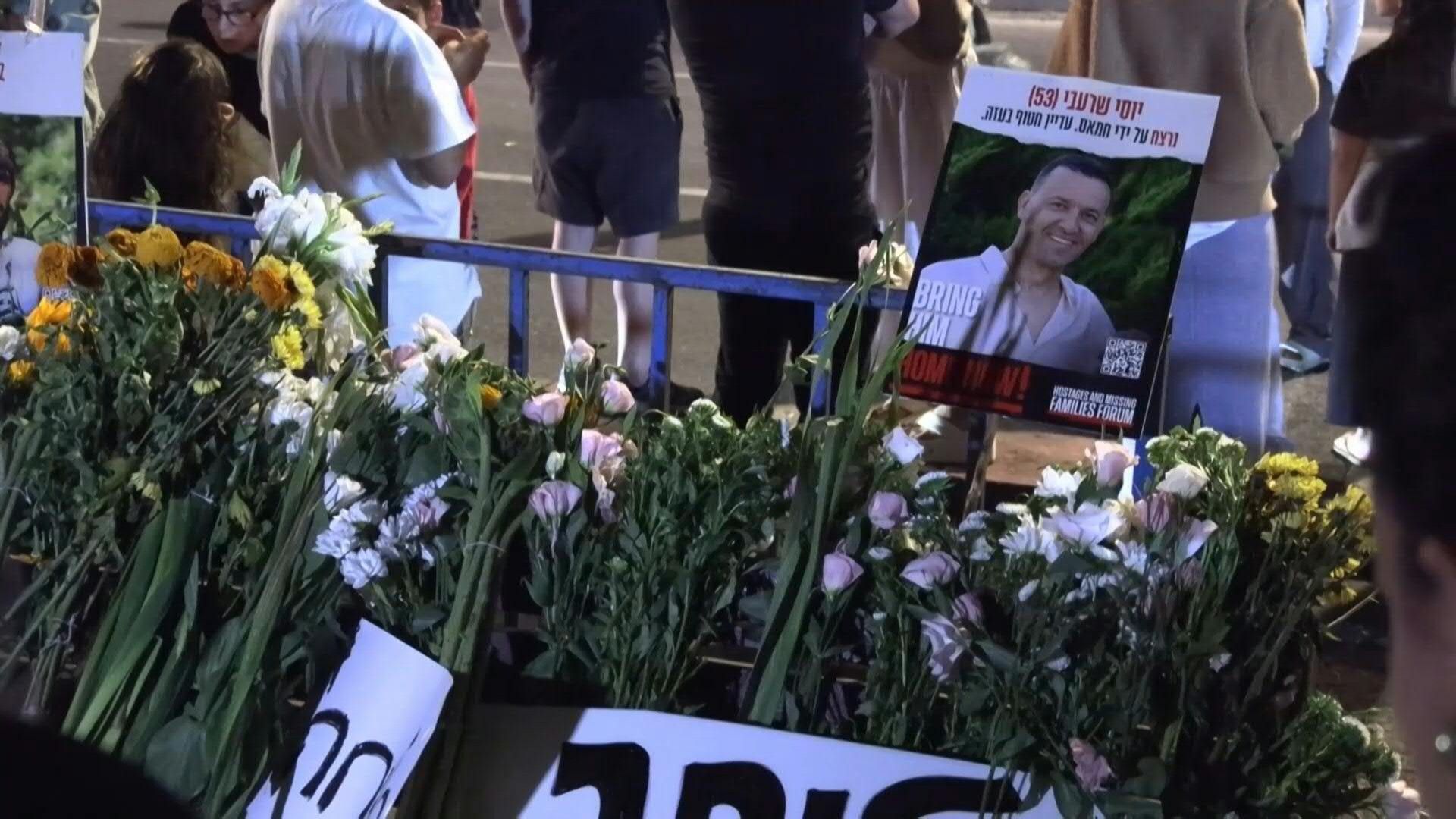Israelis lay flowers in front of forensic center after arrival of deceased Gaza hostages