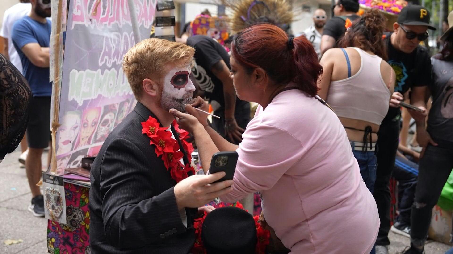 People get their makeup done before Mexico City's Day of the Dead parade
