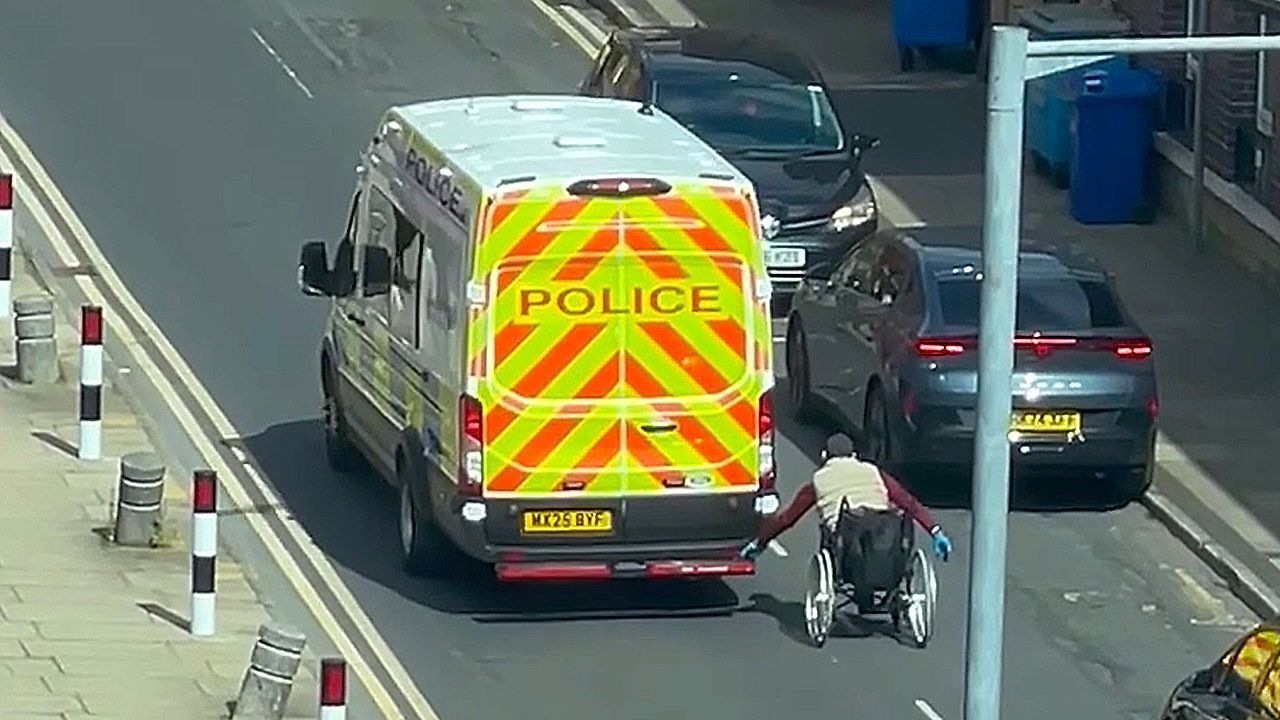 Video: Gefährlicher Spaß: Rollstuhlfahrer hängt sich an Polizeiwagen