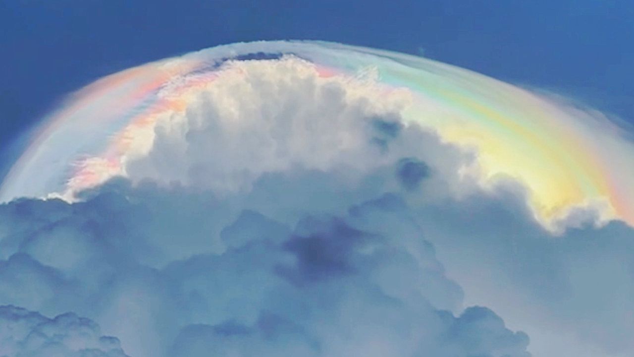 Wie ein Heiligenschein: Regenbogenwolke leuchtet über Sturmwolken