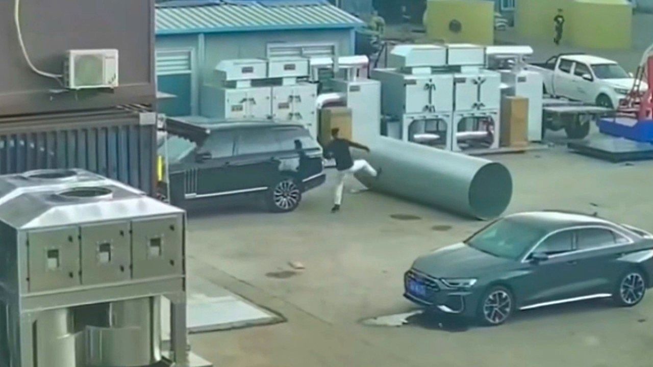 Video: Man rushes into danger as runaway steel roll heads for car