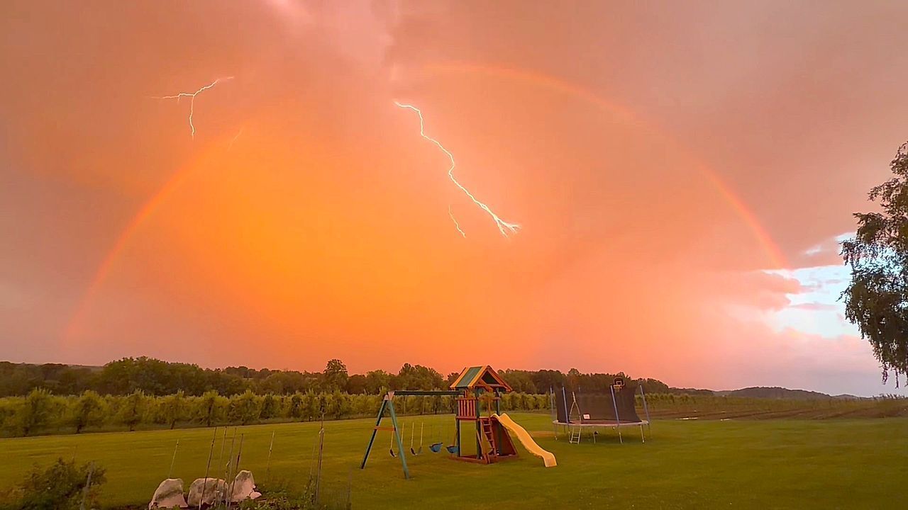 Video: Perfektes Timing: Blitz schießt mitten durch einen Regenbogen in New York